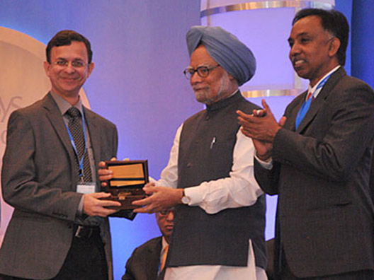 Dr. Manmohan Singh felicitates Dr. Chetan E. Chitnis, Life Sciences Laureate as Prof. Inder Verma and Mr. Shibulal S.D., Category Anchor Trustee, applaud the winner