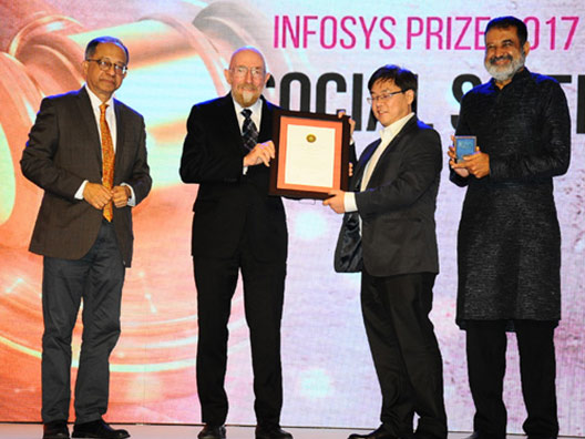 Prof Lawrence Liang receiving the Infosys Prize 2017 from Nobel Laureate Prof Kip Thorne, with Mr M D Pai and Prof Kaushik Basu