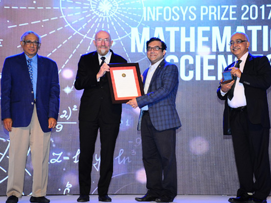 Prof Ritabrata Munshi receiving the Infosys Prize 2017 from Nobel Laureate Prof Kip Thorne, with Mr Dinesh and Prof Varadhan