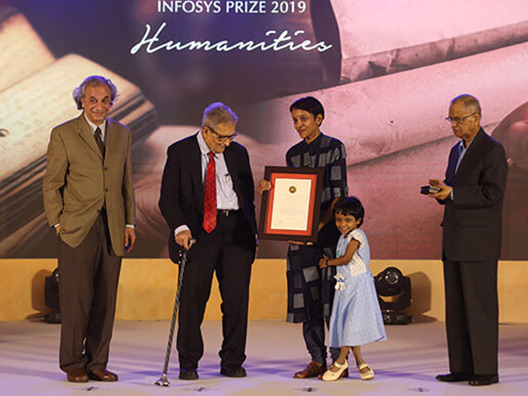 Mrs. Leena Parvathy, wife of Dr. Manu Devadevan, Infosys Prize 2019 laureate (Humanities category) receives the award on his behalf from the Chief Guest, Prof. Amartya Sen