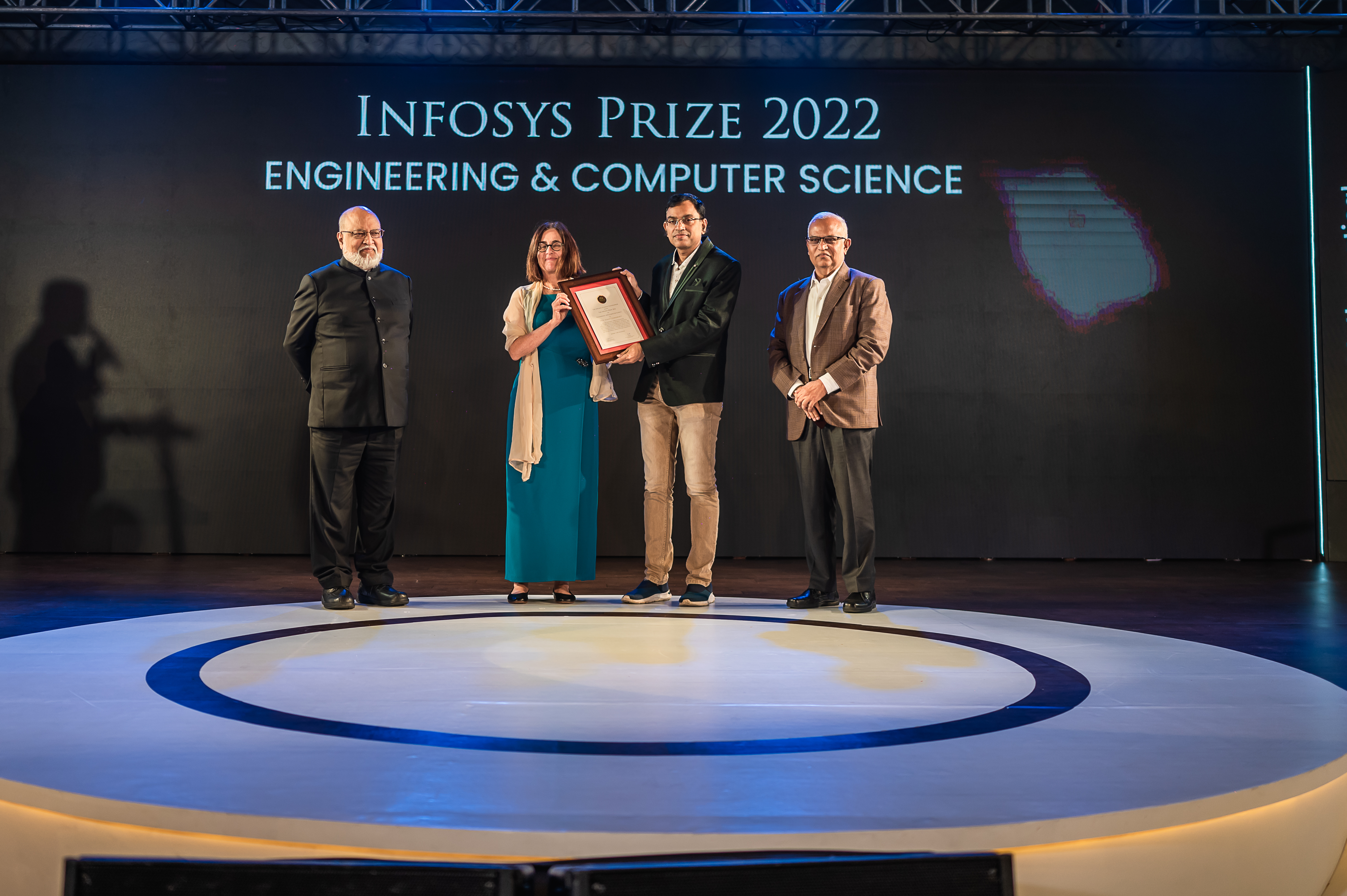 Prof. Arvind, Prof. Shafi Goldwasser and Mr. Srinath Batni presenting the Infosys Prize 2022 to Prof. Suman Chakraborty