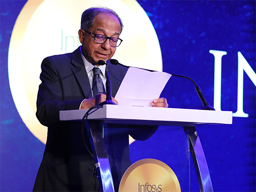 Prof. Kaushik Basu reading the jury’s citation of Prof. Arun Chandrasekhar’s work at the Infosys Prize Ceremony 2024