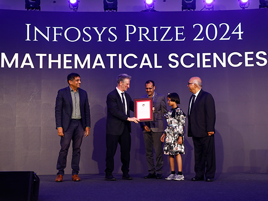 Prof. Chandrashekhar Khare, Prof. Peter Sarnak, and Mr. K. Dinesh presenting the Infosys Prize 2024 to Prof. Neena Gupta’s family