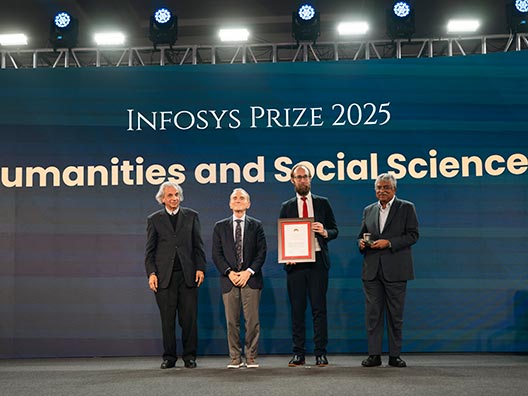 Prof. Akeel Bilgrami, Prof. Randy Schekman, and Mr. Nandan Nilekani presenting the Infosys Prize 2025 to Prof. Andrew Ollett