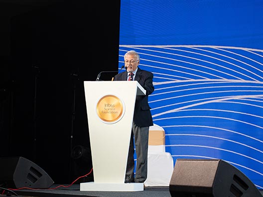 Prof. Mriganka Sur reading the jury’s citation of Prof. Anjana Badrinarayanan’s work at the Infosys Prize Ceremony 2025